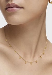 Collar de oro con una delicada cadena que presenta pequeños charms de estrellas y corazones, colgados de manera uniforme a lo largo de su longitud, realzando su diseño minimalista.