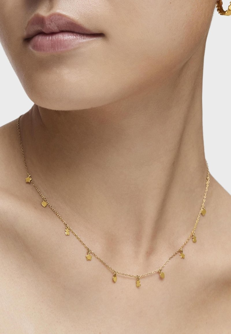 Collar de oro con una delicada cadena que presenta pequeños charms de estrellas y corazones, colgados de manera uniforme a lo largo de su longitud, realzando su diseño minimalista.