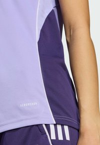 Purple athletic shirt with a light lilac panel, featuring "AEROREADY" branding, smooth texture, and contrasting white stitching.