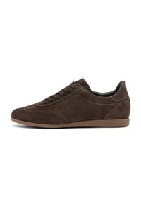 Sneaker bassa in suede marrone con lacci marroni abbinati, suola marrone chiaro e dettagli di cucitura in evidenza su sfondo bianco.