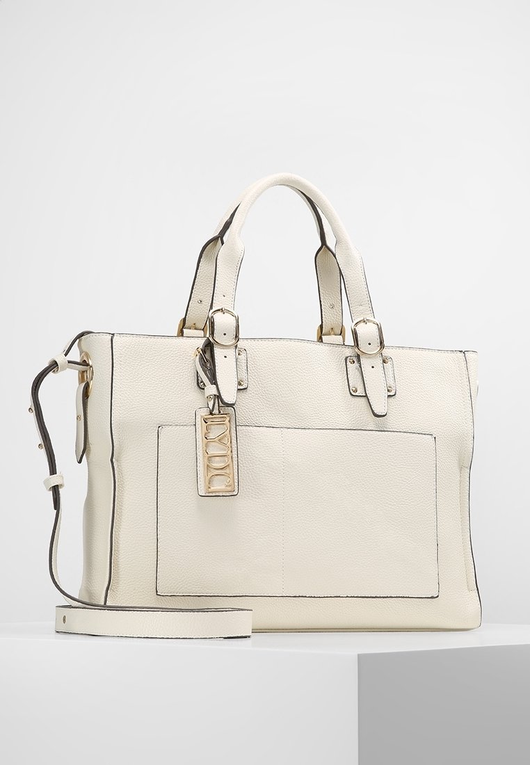 Biała skórzana torebka z fakturowanym wykończeniem, czarnymi detalami, podwójnymi uchwytami, odpinanym paskiem i przednią kieszenią. Zawiera metalową metkę z logo.