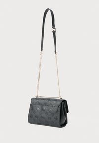 Borsa a spalla in pelle nera con motivo monogramma a rilievo, tracolla in catena dorata e sezione in pelle regolabile su sfondo bianco.