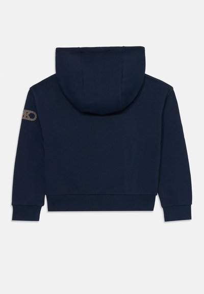 Sweat à capuche bleu marine avec manches longues, poignets et ourlet côtelés, capuche et petit logo doré sur la manche gauche.