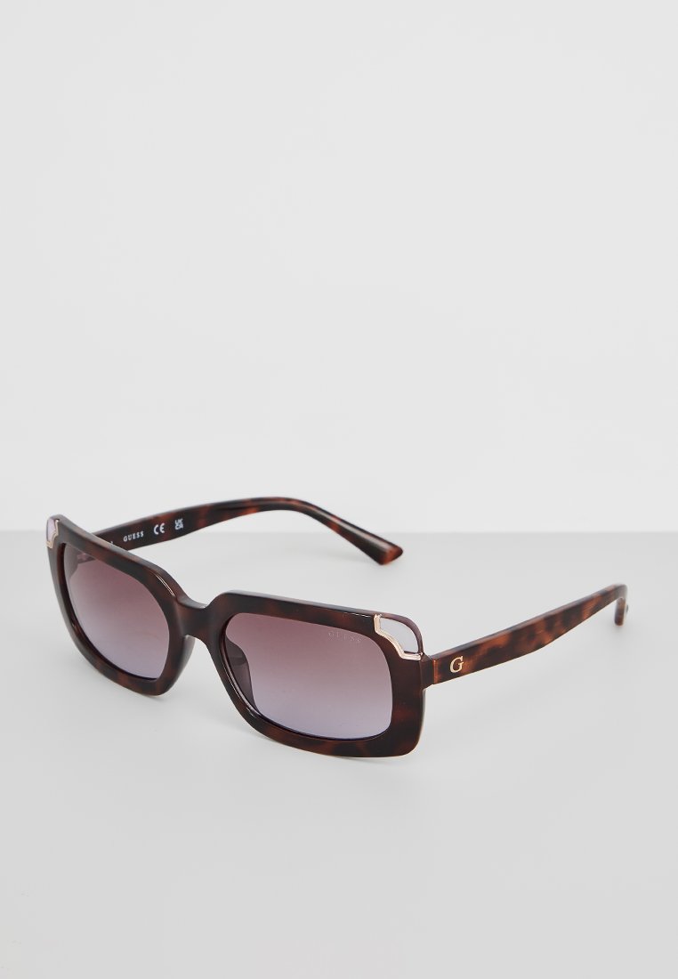Braune Schildpatt-Sonnenbrille mit Verlaufsgläsern, rechteckiger Form und goldfarbenen Akzenten auf dem Rahmen. Das Design zeichnet sich durch dicke Bügel aus.