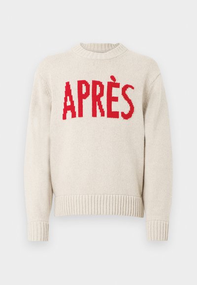 Bežinis megztinis su raukšlėtomis rankovėmis ir apačia, su ryškiai raudonu užrašu "APRÈS" krūtinėje.