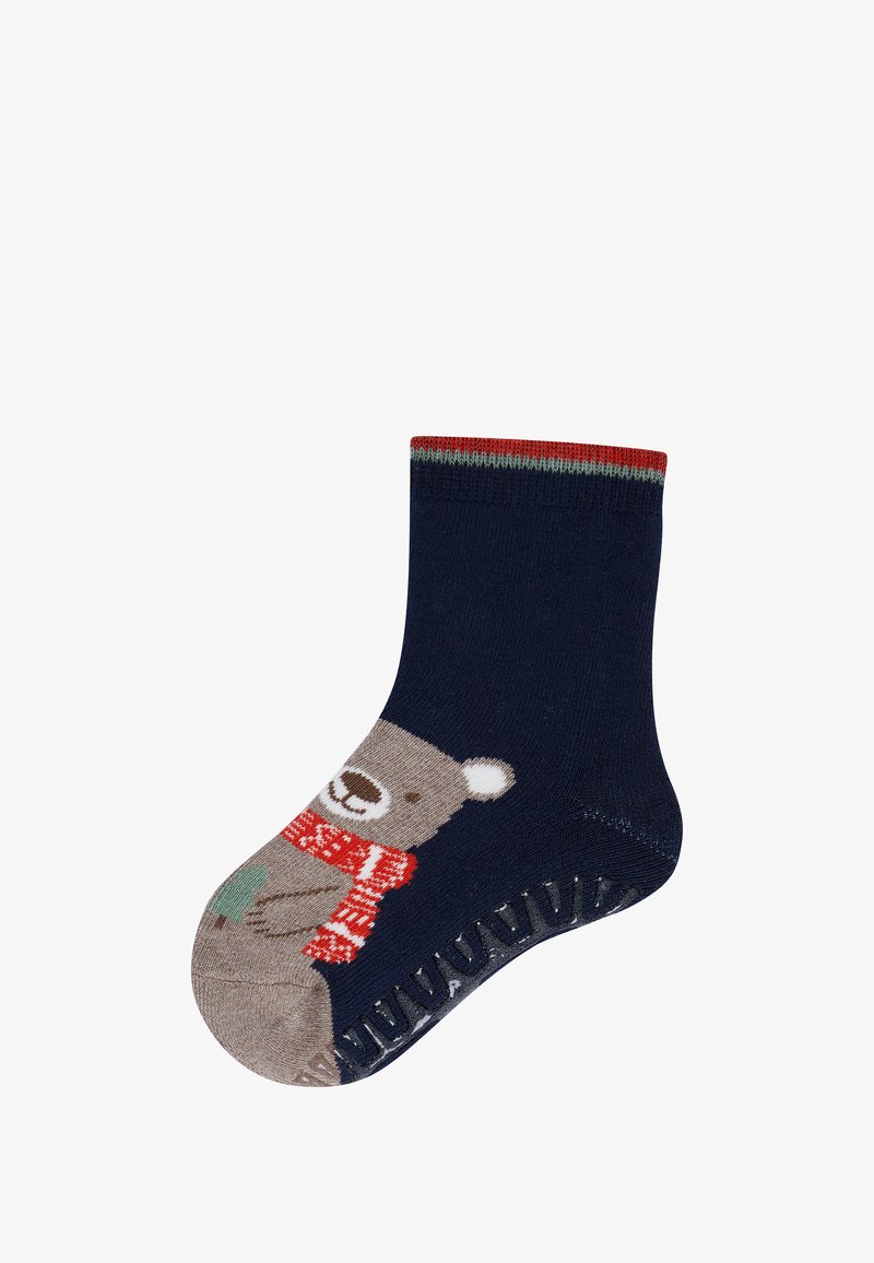 Child's navy blue sock with a brown bear wearing a red scarf and holding a green Christmas tree, featuring anti-slip grip on the sole.