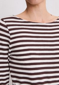 Brązowo-biały, w poziome paski, długi rękaw, bluzka z dekoltem łódkowym, wykonana z miękkiego, elastycznego materiału. Posiada równo rozmieszczone poziome paski.