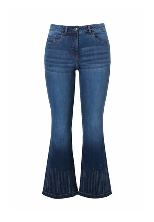 Jeans in denim svasata di colore blu scuro con un gradiente che sfuma nel blu chiaro all'orlo, caratterizzati da dettagli in metallo a forma di borchie vicino alla parte inferiore.