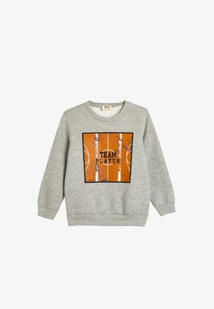 Sudadera gris hecha de un tejido suave con un gráfico de una cancha de baloncesto naranja y el texto "TEAM PLAYER" en negro, enmarcado en un cuadrado negro.