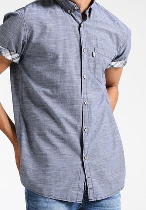 Korte mouw blouse van lichtblauwe, gestructureerde stof met een button-down kraag, voorzien van een zak en geruite accenten op de manchetten.