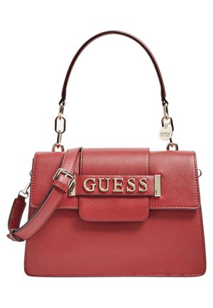 Sac à main Guess en cuir rouge avec poignée supérieure, bandoulière réglable et plaque logo dorée sur le rabat avant.