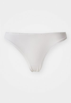 White cotton thong with a smooth texture and elastic waistband featuring the "Tommy Hilfiger" logo. Minimalist design, full coverage, and seamless edges.
