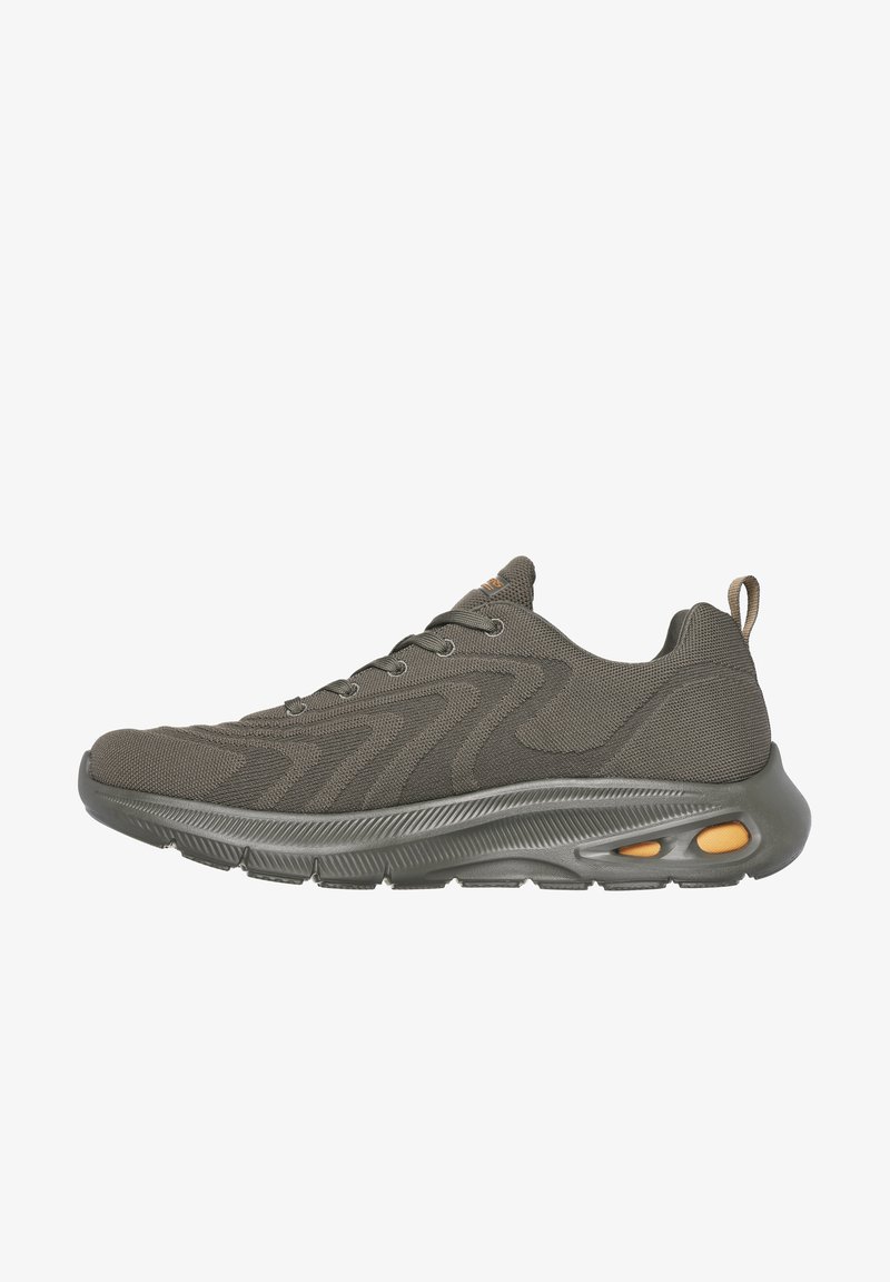 Dark olive green athletic shoe with a textured knit upper, curved sole, and orange accents near the heel, featuring a lace-up design.