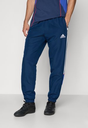 Marineblauwe sportbroek met elastische boorden en zijstrepen. Gemaakt van lichte stof, met een Adidas-logo op het linkerbeen.