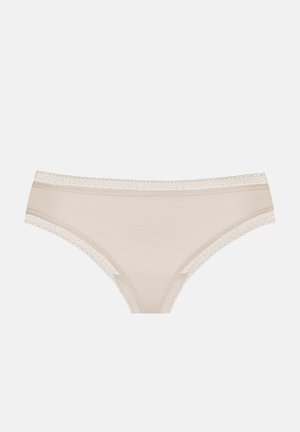 String beige en dentelle avec une texture douce et un design sans couture. Présente des accents délicats en dentelle le long de la ceinture.