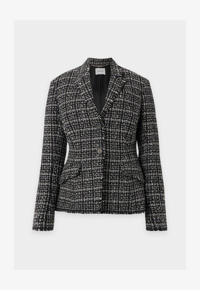 Blazer femme en tweed noir et blanc avec deux boutons sur le devant, col à revers cranté et deux poches à rabat sur fond clair.