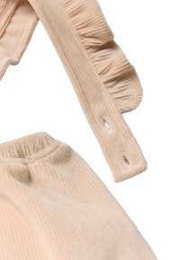 Conjunto de pana de color rosa pálido con tirantes fruncidos y cintura elástica. Presenta rayas verticales y una textura suave.