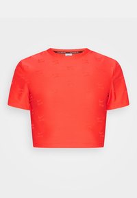 Rotes, kurzes T-Shirt mit kurzen Ärmeln, aus einem glatten, dehnbaren Material gefertigt, mit einem subtilen, überall verteilten Nike-Logo-Muster.