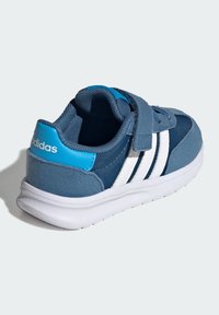 Modré športové topánky s suchým zipsom, vyrobené z semišu a sieťoviny, s bielym trojpruhovým vzorom a bielou gumovou podrážkou.