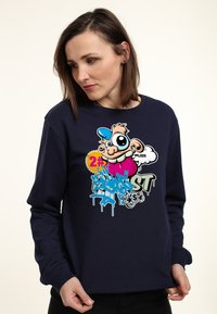 Felpa navy con un design grafico che presenta un personaggio dei cartoni animati, colori vivaci e elementi testuali in stile graffiti. Maniche lunghe e scollo rotondo.