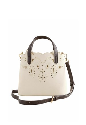 Krémová kabelka s tmavohnedými rúčkami a popruhom, s prepracovanými výrezmi kvetinových vzorov na prednej strane a vlnitým horným okrajom.