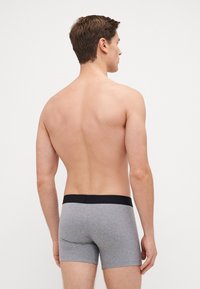 Herren graue Baumwoll-Boxershorts mit einem schwarzen elastischen Bund. Sie bieten eine eng anliegende Passform und eine glatte Textur, die für Komfort sorgt.