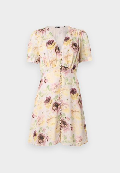Σύντομο φόρεμα με λουλούδια, V-λαιμόκοψη, φουσκωτά μανίκια και εμπρός κουμπιά με πέρλες, με κίτρινα, ροζ και μωβ ανθισμένα μοτίβα σε ανοιχτό ύφασμα.