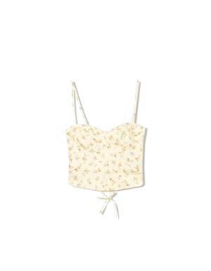 Top court à imprimé floral en tissu jaune clair, avec des bretelles fines et réglables, un corsage froncé et un nœud au bas pour ajuster la taille.