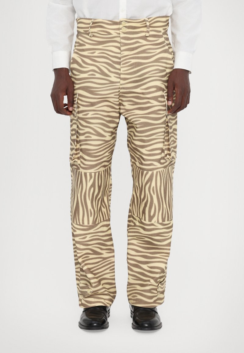 Bruine en crèmekleurige cargo broek met zebra-strepen, voorzien van zijzakken en een losse pasvorm, gemaakt van lichtgewicht stof. Heeft drukknoopsluiting bij de broekspijpen.