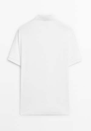 Hvid polo t-shirt med korte ærmer og standardkrave i blødt stof. Har en glat tekstur og et rent, enkelt design uden pynt.