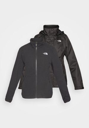Dvoslojna jakna u crnoj boji: fleece s patentnim zatvaračem, visokim kragnom i vodootpornom školjkom s kapuljačom; uključuje logotipe na oba sloja.