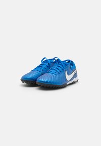 Zapatillas deportivas azules con una parte superior sintética suave, diseño texturizado, el logo de Nike en blanco y suela de goma negra para tracción.