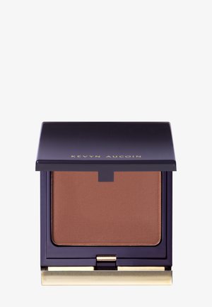 Kompakter Bronzer mit mattem, mittelbraunem Puder im Inneren. Tieflila Gehäuse mit goldenen Akzenten, das einen magnetischen Verschluss hat.