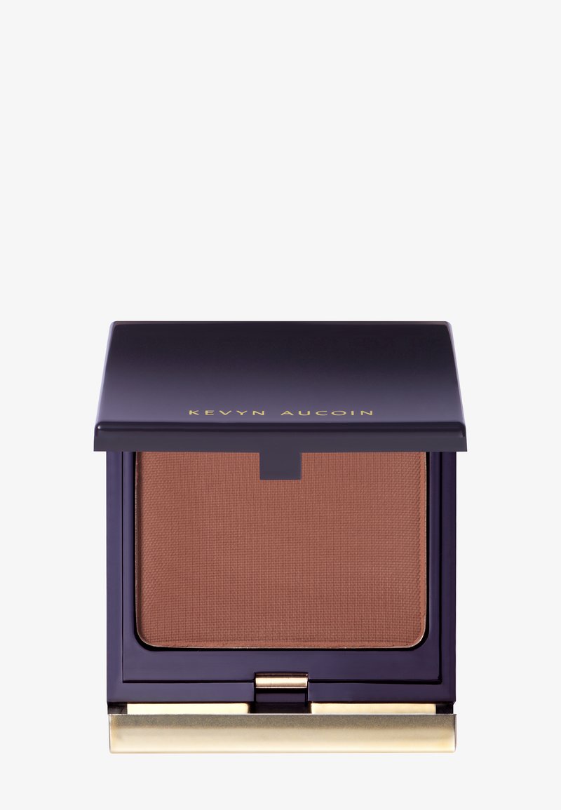 Kompakt bronzer med et mat, medium brunt puder indeni. Dyb lilla etui med gyldne accenter, der har en magnetisk lukning.