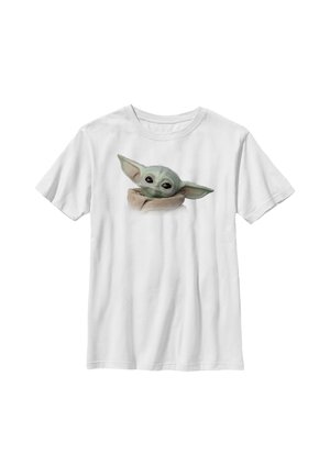 Biały T-shirt z krótkim rękawem z nadrukowaną ilustracją małej, zielonej postaci z dużymi uszami, owiniętej w brązową szatę na przodzie.