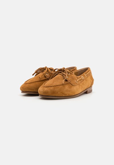 Mocassini in suede di un ricco color tan, con punta arrotondata, design con lacci e suola in gomma marrone chiaro con sottili dettagli di cucitura.