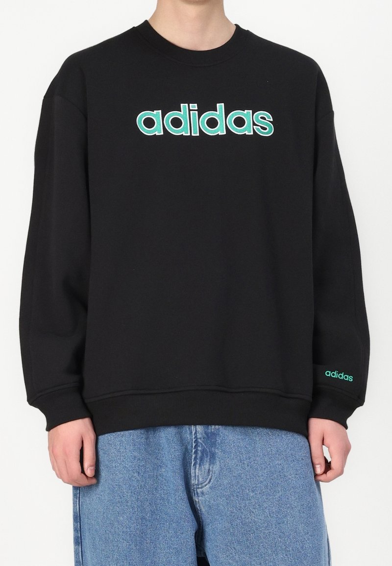 Svart sweatshirt i bomullsblandning, med en stor turkos "adidas"-logotyp på framsidan och en mindre logotyp på ärmen.