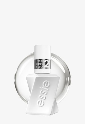 Flacon blanc de vernis à ongles Essie portant la mention « top coat step 2 », avec un bouchon blanc et un échantillon circulaire transparent de vernis derrière.
