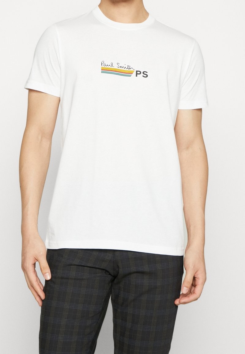 Bílá bavlněná tričko s krátkými rukávy, s barevným logem "Paul Smith" a textem "PS" na hrudi. Texturovaná látka, volný střih.