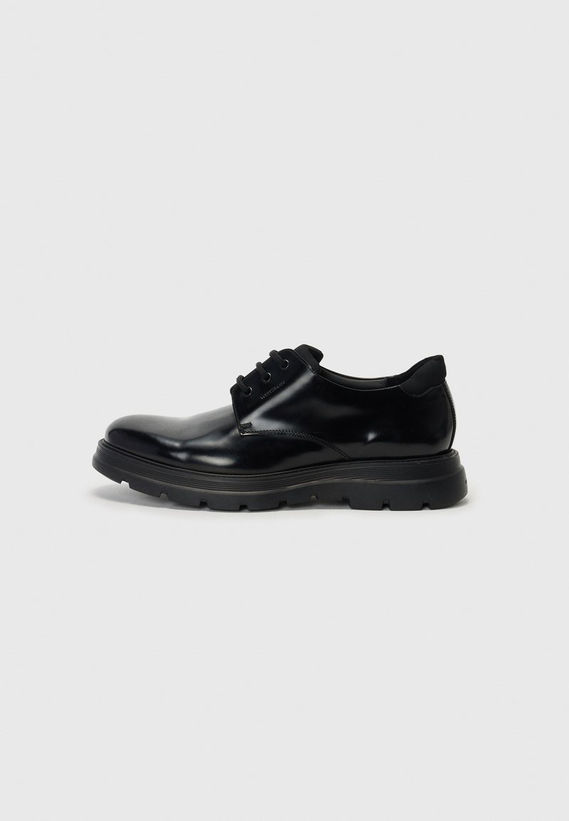 Black leather lace-up shoe with smooth finish, durable rubber sole, and rounded toe. Features eyelets for laces and subtle branding.