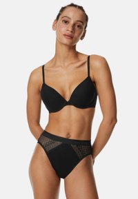 Set di lingerie nera composto da un reggiseno imbottito con bretelle regolabili e uno slip a vita alta con accenti in pizzo e una cintura solida.