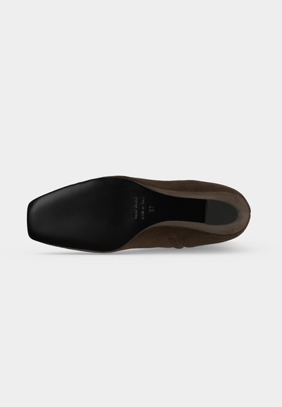 Chaussure en daim marron avec une semelle noire carrée, vue par le dessous montrant les marquages de taille et de marque.