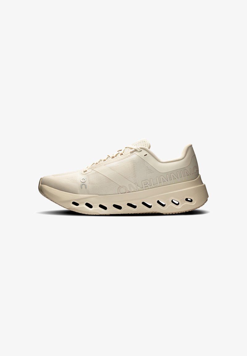 Chaussure de course beige avec dessus en mesh respirant, semelle coussinée présentant des découpes ovales, et logo "ON RUNNING" sur le côté.