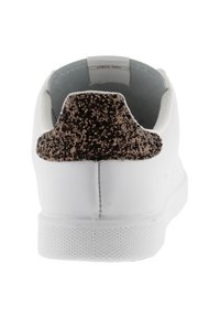 Sneaker bianco visto da dietro con un tallone glitterato nero e marrone testurizzato e un'etichetta "Dal 1915" visibile all'interno.