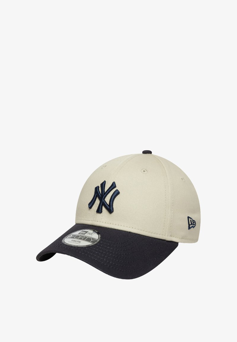 Cappello di cotone beige con visiera blu navy, dotato di un logo ricamato blu navy sulla parte anteriore e di un'etichetta con marchio sul lato. Texture liscia.