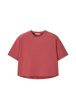T-shirt court à manches courtes, coupe ample et courte, de couleur rouge brique sourde, avec un col rond et sans motifs ni logos visibles.