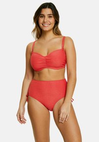 Bikini rouge en deux pièces fait d'un tissu avec un subtil éclat. Le haut présente des fronces, des bretelles réglables, et le bas taille haute a des liens latéraux.