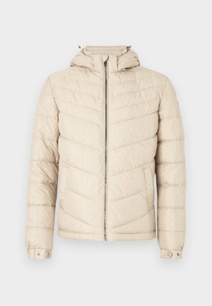 Bézs tépőzáras puffdzseki steppelt kivitelben, cipzáras elülső résszel, állítható kapucnival és mandzsetta patentokkal. Könnyű, fényes anyagból készült.