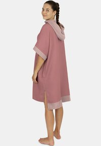 Häkelte Kapuzenrobe aus einem strukturierten pinken Stoff, mit einem gespaltenen Saum und kontrastierenden texturierten Bündchen. Weiches Material und lockere Passform für hohen Tragekomfort.