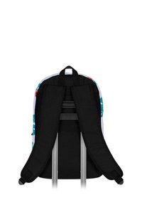 Correas de tela negra de una mochila, con un exterior de diseño colorido. Se ven correas ajustables y un asa en la parte superior.